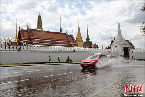 当时10月29日,湄南河水位继续上涨,泰国湾的高海潮水又奔袭而至,洪水越过湄南河防洪堤进至曼谷著名景点玉佛寺。图为当日中午进袭寺前的洪水已呈强弩之末,但有车驶过仍激起阵阵浪花。 当时10月29日,湄南河水位继续上涨,泰国湾的高海潮水又奔袭而至,洪水越过湄南河防洪堤进至曼谷著名景点玉佛寺。图为当日中午进袭寺前的洪水已呈强弩之末,但有车驶过仍激起阵阵浪花。