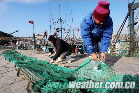 2011年11月30日,山东青岛积米崖渔港渔船停靠在渔港避风,渔民在修补渔网。(俞方平 摄) 2011年11月30日,山东青岛积米崖渔港渔船停靠在渔港避风,渔民在修补渔网。(俞方平 摄)